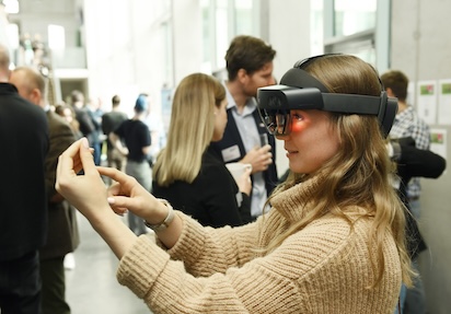 Junge Frau mit VR-Brille probiert eine Mixed Reality-Anwendung aus